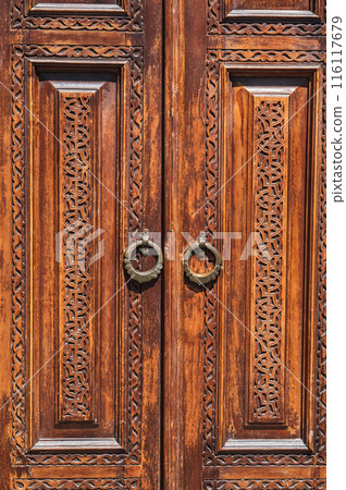 traditional Asian Uzbek patterns arabesque ornament on an ancient wooden carved door in Uzbekistan 116117679