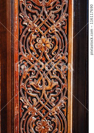 arabic tajik Islamic kandakori patterns arabesque ornament on ancient wooden carved door in Tajikistan close-up arabic tajik Islamic kandakori patterns arabesque ornament on ancient wooden carved door in Tajikistan close-up 116117690