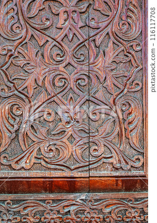 arabic Uzbek Islamic kandakori patterns arabesque ornament on an wooden carved door in Uzbekistan close-up 116117708