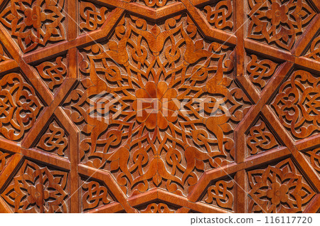 traditional Arabic Uzbek Islamic patterns arabesque ornament on an wooden carved door in Uzbekistan 116117720