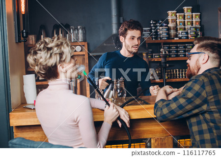 kind friendly barmen is talking with visitors at the cafe kind friendly barmen is talking with visitors at the cafe 116117765