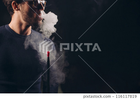 attractive man exhaling smoke from the nose attractive man exhaling smoke from the nose 116117819