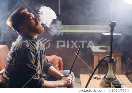 ginger emotional man blowing smoke at the cafe 116117924