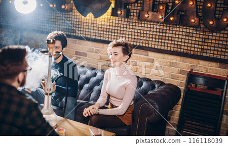 awesome young people having fun while smoking hookah awesome young people having fun while smoking hookah 116118039
