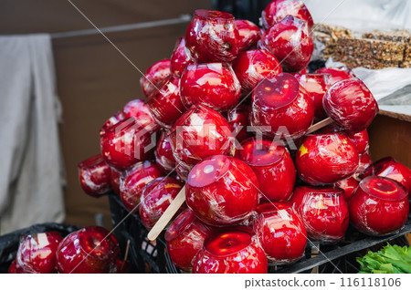 sweet candy apples on market shelf. Red caramel apples on sticks on counter at bazaar sweet candy apples on market shelf. Red caramel apples on sticks on counter at bazaar 116118106
