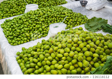 unripe green apricot on counter of the Chorsu Bazaar in Tashkent. Traditional Uzbek food dovcha, gura, green uryuk 116118112