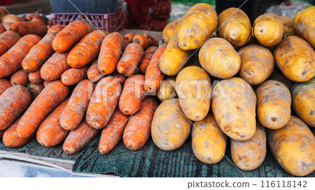 fresh harvest of orange and yellow carrots on shelves of vegetable farmers bazaar fresh harvest of orange and yellow carrots on shelves of vegetable farmers bazaar 116118142