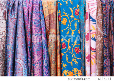 silk scarves with a bright colorful pattern at oriental bazaar in Tashkent in Uzbekistan close-up 116118241