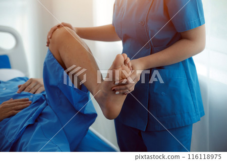 Physical therapists work with patients in close-up clinics. The concept of rehabilitation of physical health, the doctor gives advice to the patient. Ankle problems and muscle injuries Physical therapists work with patients in close-up clinics. The concept of rehabilitation of physical health, the doctor gives advice to the patient. Ankle problems and muscle injuries 116118975