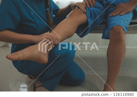 Physical therapists work with patients in close-up clinics. The concept of rehabilitation of physical health, the doctor gives advice to the patient. Ankle problems and muscle injuries Physical therapists work with patients in close-up clinics. The concept of rehabilitation of physical health, the doctor gives advice to the patient. Ankle problems and muscle injuries 116118980