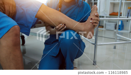 Physical therapists work with patients in close-up clinics. The concept of rehabilitation of physical health, the doctor gives advice to the patient. Ankle problems and muscle injuries Physical therapists work with patients in close-up clinics. The concept of rehabilitation of physical health, the doctor gives advice to the patient. Ankle problems and muscle injuries 116118985