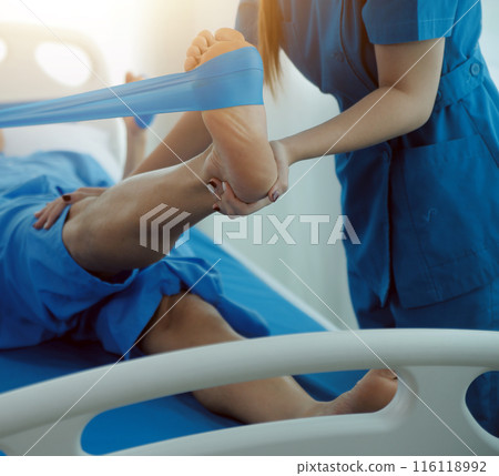Physical therapists work with patients in close-up clinics. The concept of rehabilitation of physical health, the doctor gives advice to the patient. Ankle problems and muscle injuries Physical therapists work with patients in close-up clinics. The concept of rehabilitation of physical health, the doctor gives advice to the patient. Ankle problems and muscle injuries 116118992