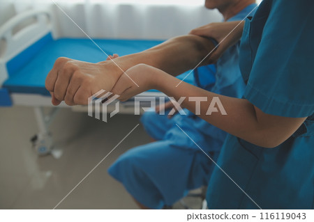 Physiotherapist man giving exercise with dumbbell treatment About Arm and Shoulder of athlete male patient Physical therapy concept 116119043