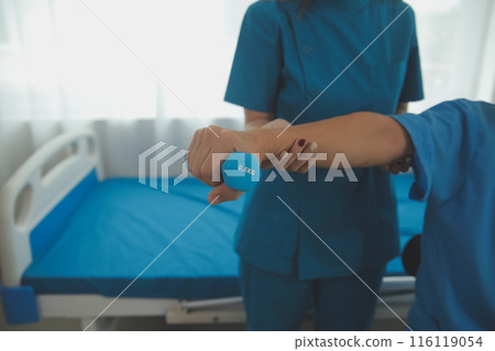 Physiotherapist man giving exercise with dumbbell treatment About Arm and Shoulder of athlete male patient Physical therapy concept Physiotherapist man giving exercise with dumbbell treatment About Arm and Shoulder of athlete male patient Physical therapy concept 116119054
