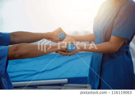 Physiotherapist man giving exercise with dumbbell treatment About Arm and Shoulder of athlete male patient Physical therapy concept 116119063