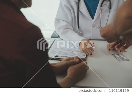 Doctor prescribing medicine giving pills to senior grandmother patient at hospital. 116119159