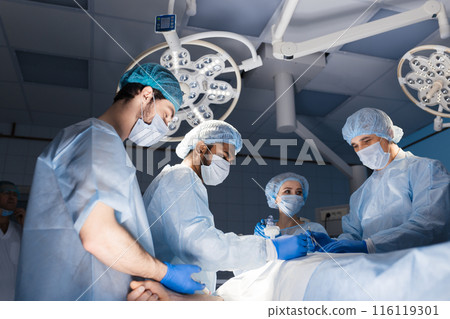 Surgeons perform a complex operation to save a human life at hospital Surgeons perform a complex operation to save a human life at hospital 116119301
