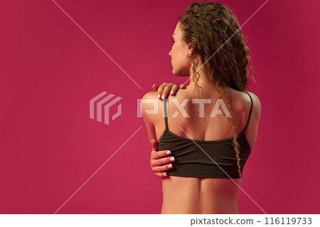 Back health. Cropped image of female back, woman posing in underwear against magenta studio background Back health. Cropped image of female back, woman posing in underwear against magenta studio background 116119733