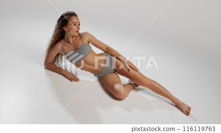 Graceful Confident. Beautiful young girl with slim, fit body shape posing in underwear on against grey studio background Graceful Confident. Beautiful young girl with slim, fit body shape posing in underwear on against grey studio background 116119765