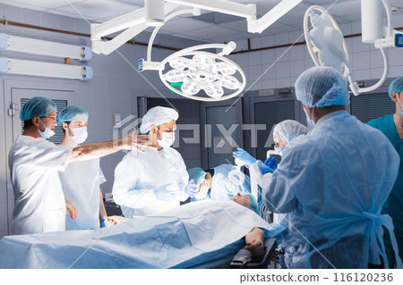 Medical Team Performing Surgical Operation in Bright Modern Operating Room 116120236