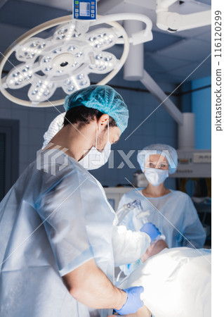 Male and female anesthetists preparing patient before operation in hospital Male and female anesthetists preparing patient before operation in hospital 116120299