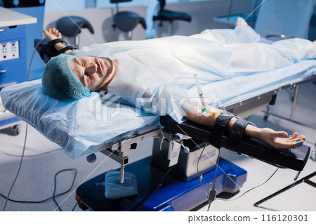 Male Patient prepared by a team of anesthetists for abdominal surgery, hospital 116120301