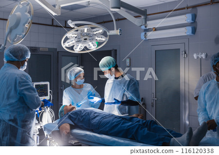 Surgery preparations. Surgical team preparing their patient for surgery Surgery preparations. Surgical team preparing their patient for surgery 116120338