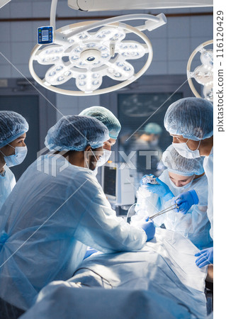 Diverse Team of surgeon, assistants and nurses making invasive surgery Diverse Team of surgeon, assistants and nurses making invasive surgery 116120429
