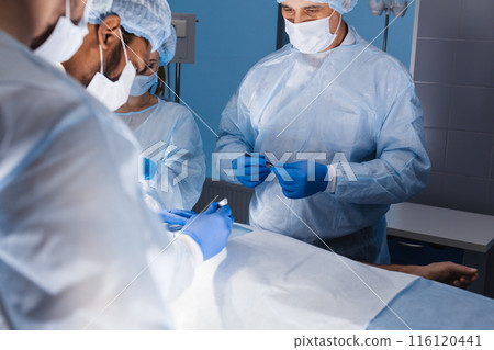 Diverse Team of surgeon, assistants and nurses making invasive surgery Diverse Team of surgeon, assistants and nurses making invasive surgery 116120441