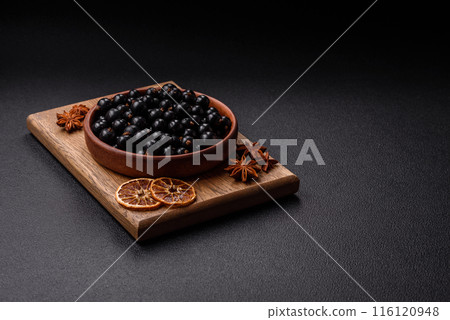 Ripe blackcurrant berries in droplets of water in a ceramic bowl 116120948
