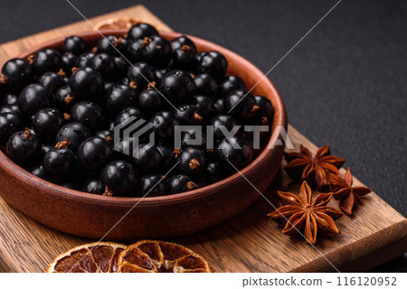 Ripe blackcurrant berries in droplets of water in a ceramic bowl 116120952