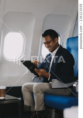 Handsome businessman checking email on laptop while sitting comfortable seat in aircraft cabin during flight. Handsome businessman checking email on laptop while sitting comfortable seat in aircraft cabin during flight. 116121038