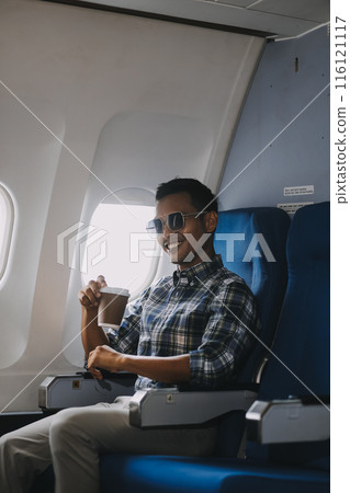 Asian man enjoying enjoys a coffee comfortable flight while sitting in the airplane cabin, Passengers near the window. 116121117
