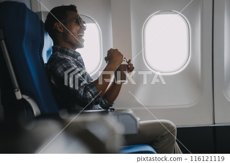 Asian man enjoying enjoys a coffee comfortable flight while sitting in the airplane cabin, Passengers near the window. 116121119