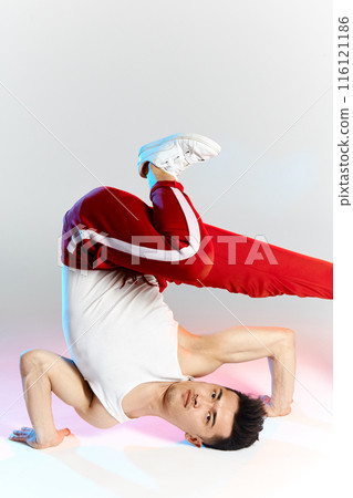 asian b-boy exercising in break dance on white background doing shoulder freeze asian b-boy exercising in break dance on white background doing shoulder freeze 116121186