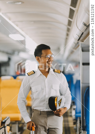 Portrait of a trained airplane captain in uniform preparing to fly in a simulator cockpit. 116121192