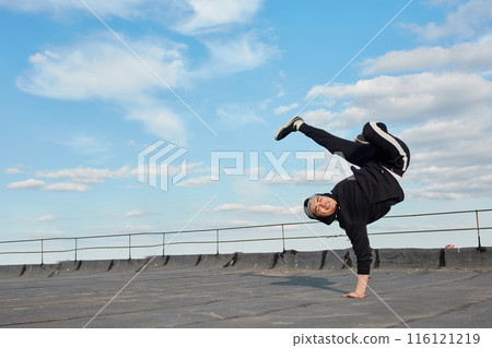 Asian hip-hop man dancer making a backdancing stunts outdoor on the roof Asian hip-hop man dancer making a backdancing stunts outdoor on the roof 116121219