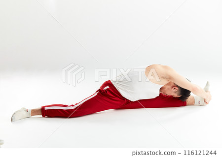 Asian handsome dancer stretching his legs before bboying. Asian handsome dancer stretching his legs before bboying. 116121244