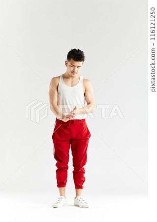 Korean gymnast in white undershirt and red sweatpants looking at camera. Korean gymnast in white undershirt and red sweatpants looking at camera. 116121250