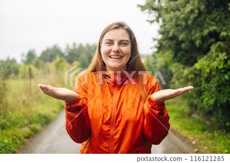 Happy woman hand catching rain drops, enjoying spring rain falling on park background. Happy woman hand catching rain drops, enjoying spring rain falling on park background. 116121285