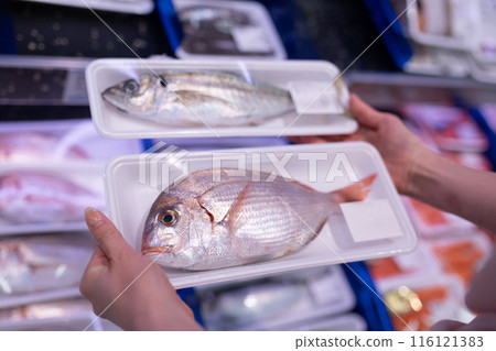 Woman's hands choosing fish Woman's hands choosing fish 116121383