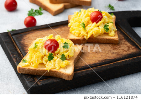 Healthy vegetarian breakfast . Scrambled eggs toast with cherry tomatoes and parsley 116121874