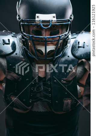 Portrait of american football player in protective shields on naked torso Portrait of american football player in protective shields on naked torso 116121925