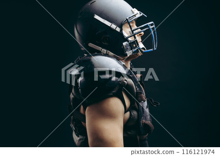 American football player with ball wearing helmet and protective shields American football player with ball wearing helmet and protective shields 116121974