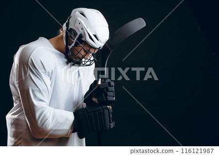 Caucasian hockey player, in uniform, isolated on black, prays for good luck. 116121987