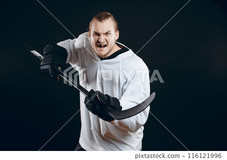 Hockey player shoots the puck and attacks, isolated over black background. Hockey player shoots the puck and attacks, isolated over black background. 116121996