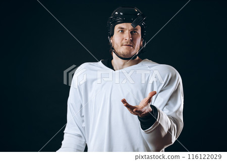 Hockey player bites the puck with broken teeth and looking at camera with a grin. Hockey player bites the puck with broken teeth and looking at camera with a grin. 116122029