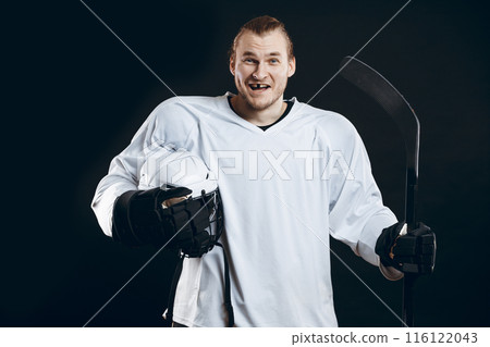 Handsome hockey player. Smiling at camera isolated on black background. Handsome hockey player. Smiling at camera isolated on black background. 116122043