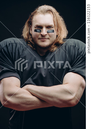 Determined American football player posing with painted face and chewing gum 116122153