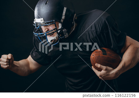 American football sportsman player in action isolated over black studio wall American football sportsman player in action isolated over black studio wall 116122156